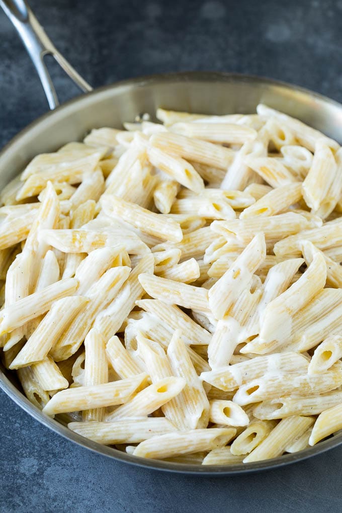 Penne mezclado con una salsa cremosa.