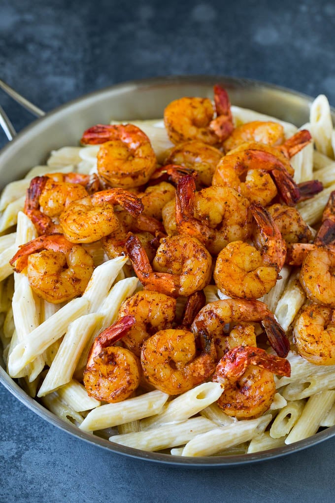 Camarones cajún picantes sobre pasta cremosa.