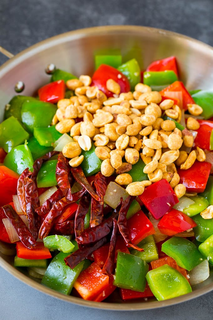 Pimientos, cacahuetes y pimientos rojos en una sartén.