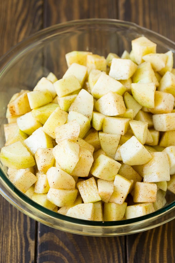 Receta de manzana crujiente |  Postre de manzana #manzanas #postre # hornear # otoño #dinneratthezoo Manzanas en cubos mezcladas con azúcar y canela en un bol.