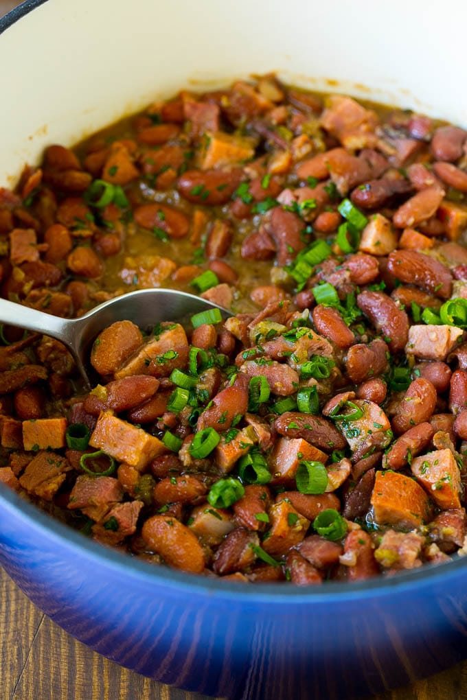 Una olla de frijoles rojos y arroz con salchicha aderezado con hierbas frescas.