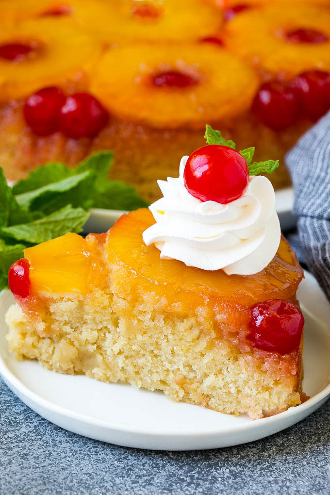 Pastel de piña al revés | Pastel de piña # tarta #ananas #postre #berry #dinneratthezoo Una rebanada de tarta de piña invertida cubierta con crema batida y una cereza.