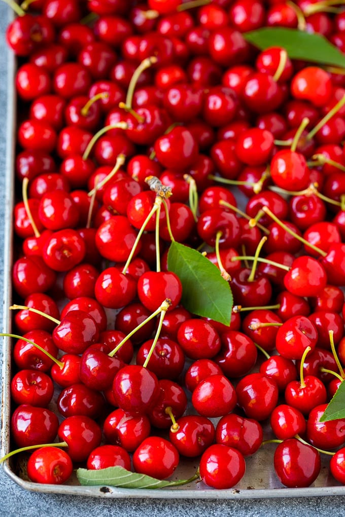 Cerezas frescas esparcidas en una bandeja para hornear.