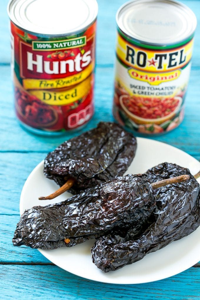 Esta receta de chile de Colorado es un platillo tradicional mexicano hecho con tierna carne de res cocinada a fuego lento en una sabrosa salsa de tomate.  ¡Es el acompañamiento perfecto para burritos, enchiladas y tacos! Latas de tomates secos y pimientos en un plato.