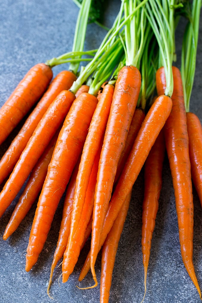 Un manojo de zanahorias en miniatura con puntas verdes.