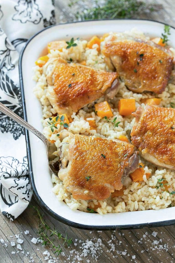 Esta sartén de pollo y arroz al horno combina pollo con arroz parmesano cremoso y calabaza para una comida completa y saludable con menos platos para limpiar.