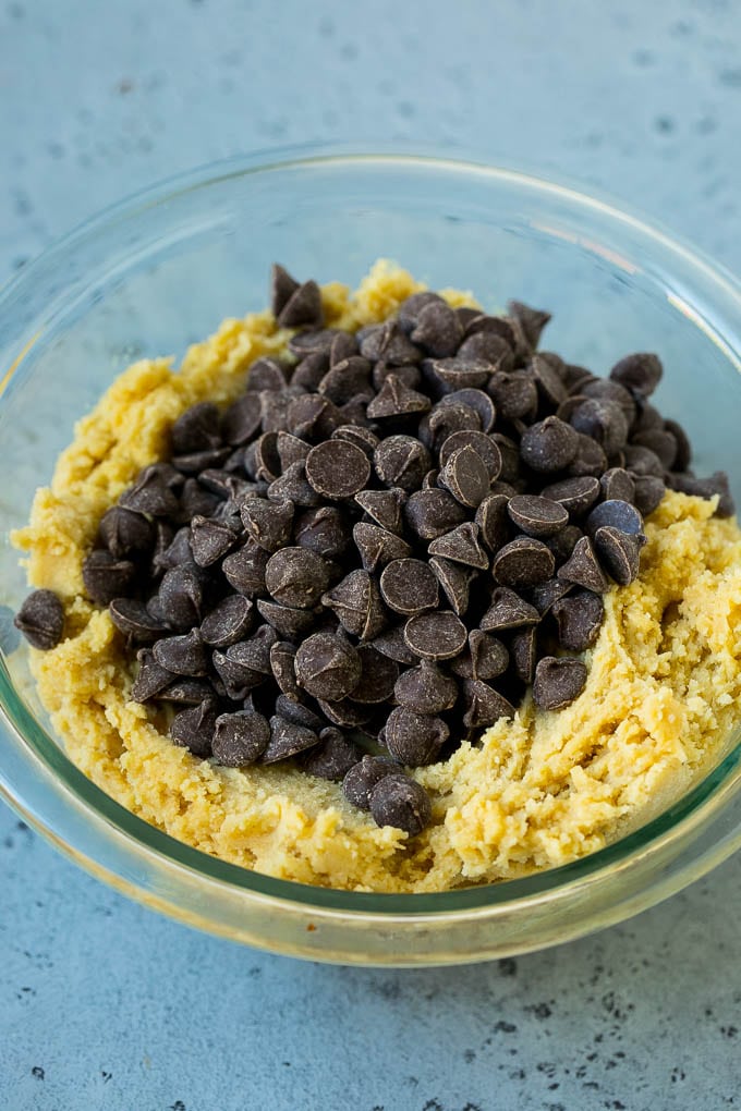 Un tazón de masa para galletas con chispas de chocolate encima.