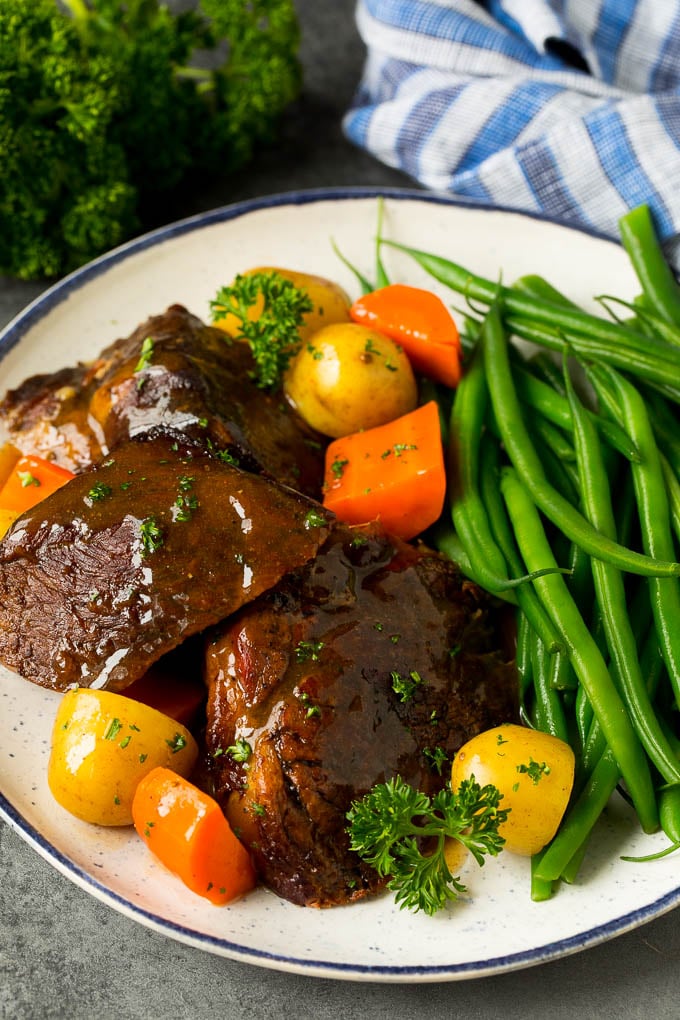 Asado en olla de cocción lenta servido con zanahorias, papas y judías verdes.