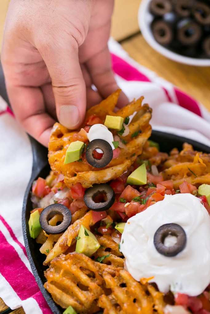 Las papas fritas están cubiertas con aderezos a base de nachos para un refrigerio divertido y delicioso.