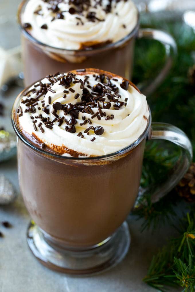 Una taza de chocolate caliente en olla de cocción lenta cubierta con crema batida.