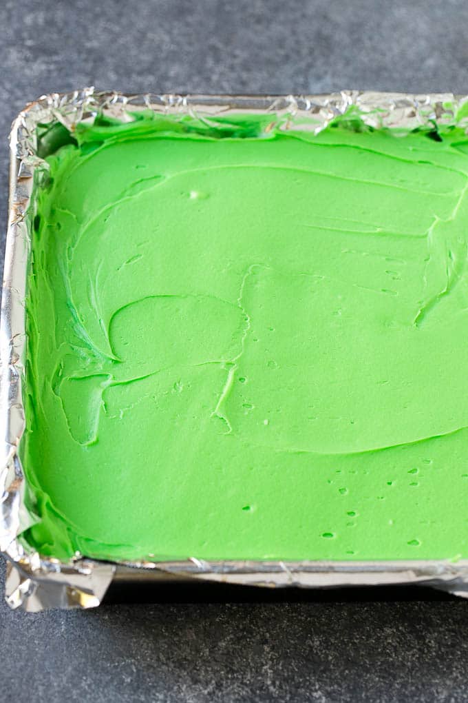 Receta de brownie de menta | Brownies en capas | Brownies helados #brownies #chocolate #frosting #mint #postre #dinneratthezoo Una capa de glaseado de menta verde se extendió sobre los brownies.
