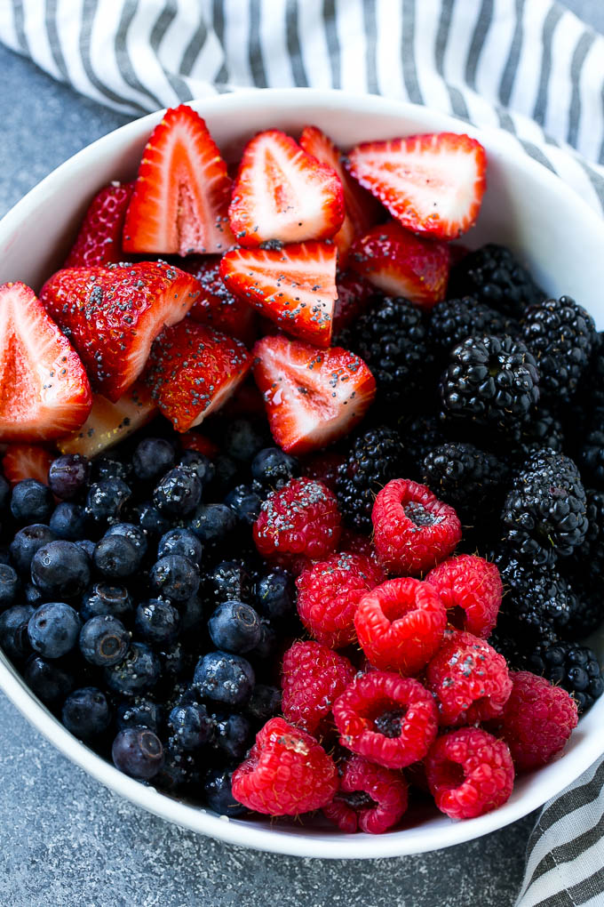 Un tazón de arándanos, frambuesas, moras y fresas con aderezo de semillas de amapola.