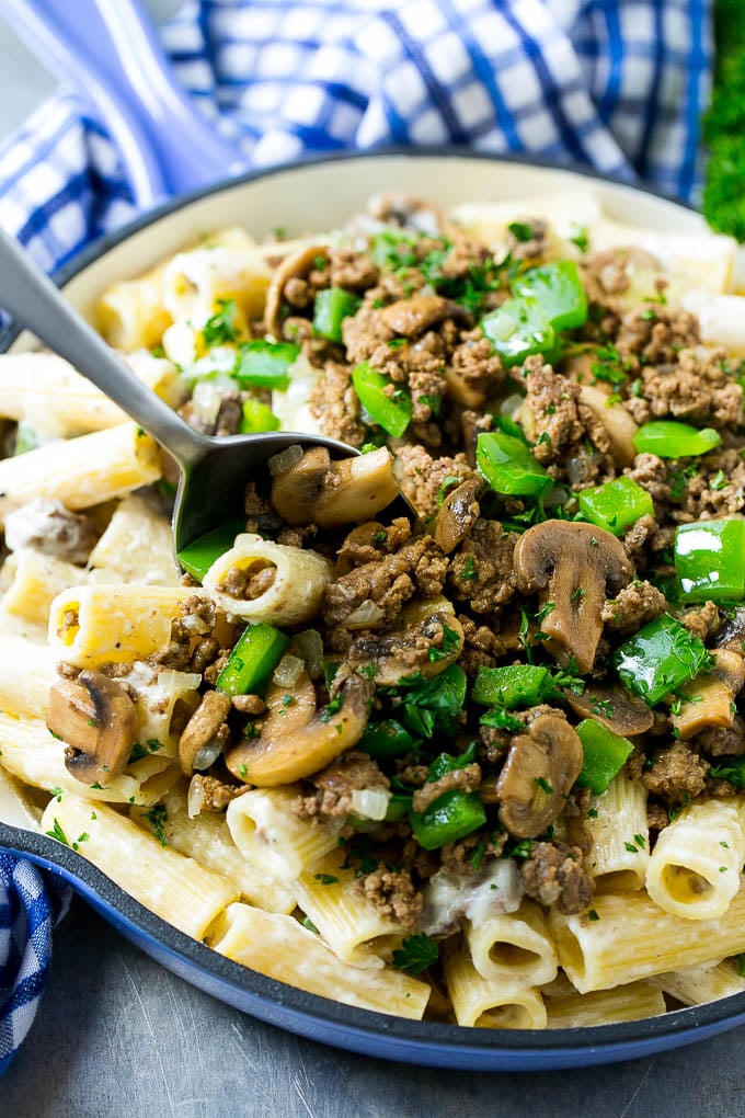 Una olla de Philly Cheesesteak con una cuchara para servir.