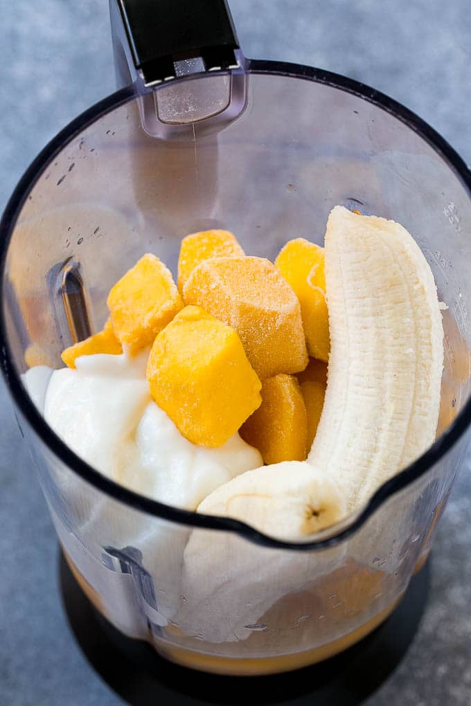 Receta de batido de mango | Receta de mango | Batido saludable #mango #smoothie #drink #dinneratthezoo Mango, plátano, yogur y jugo congelados en una licuadora.