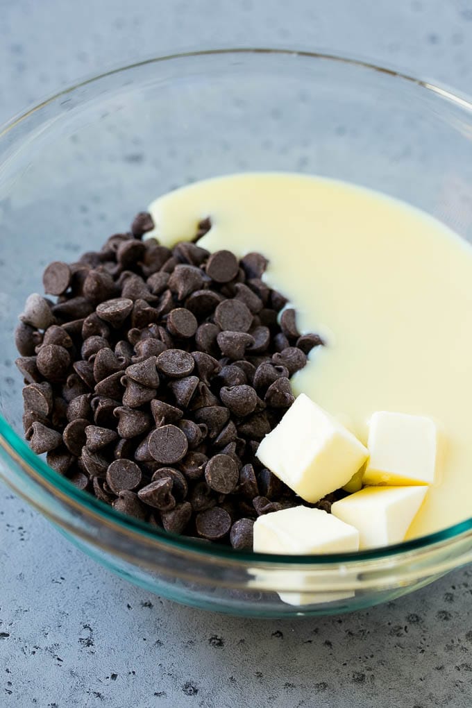 Receta de dulce de chocolate con mantequilla de maní |  Fudge de mantequilla de maní |  Receta fácil de dulce de azúcar # Chocolate # Mantequilla de maní # Dulce de azúcar # Hornear # Postre # Cena Gotas de chocolate, leche condensada y mantequilla en un bol.