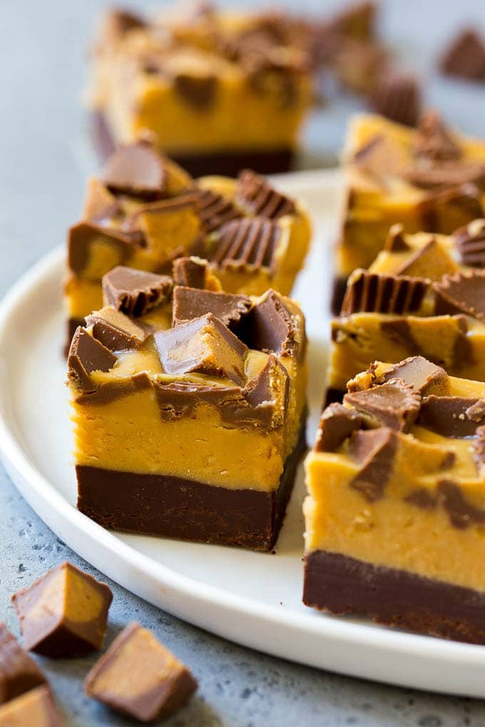 Receta de dulce de chocolate con mantequilla de maní |  Fudge de mantequilla de maní |  Receta fácil de dulce de azúcar # Chocolate # Mantequilla de maní # Dulce de azúcar # Hornear # Postre # Cena Cuadritos de chocolate amargo de mantequilla de maní cubiertos con tazas de mantequilla de maní.