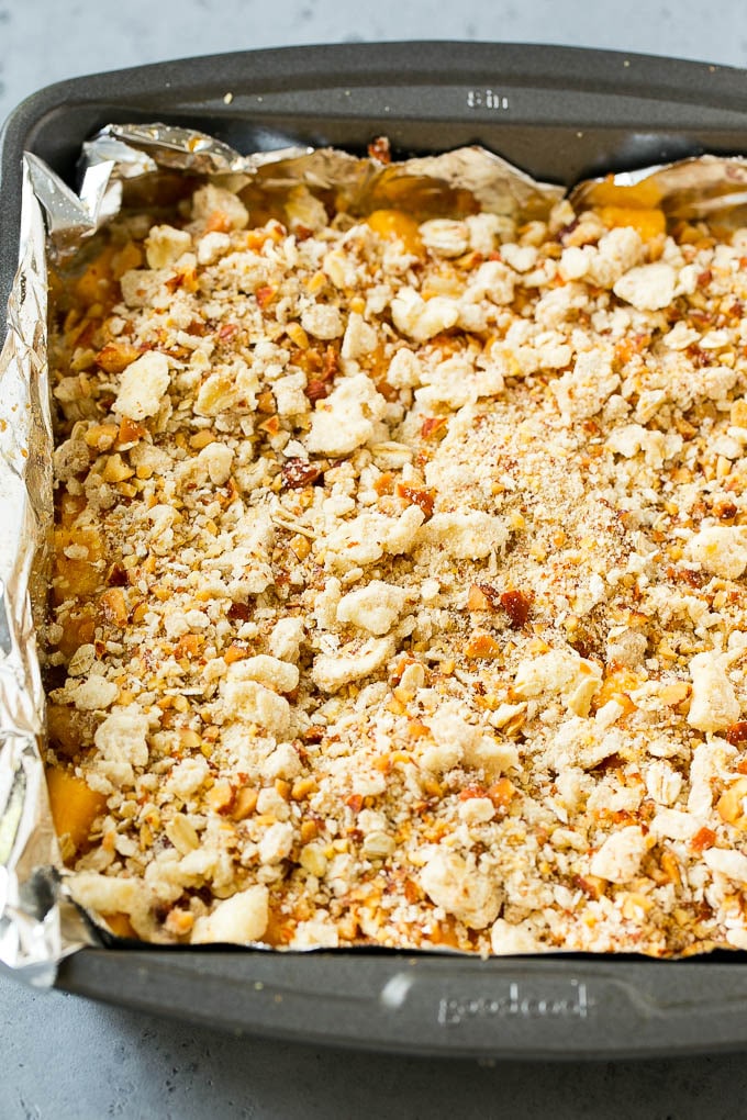 Una cazuela de crumble de melocotón crudo.