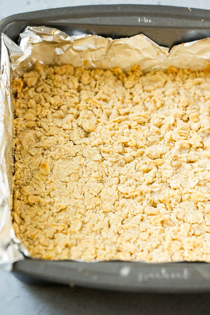 Una costra de avena y azúcar morena prensada en una cacerola.