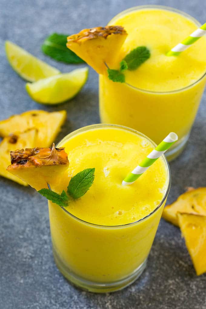 Vasos de batido de piña mixto con guarnición de menta.