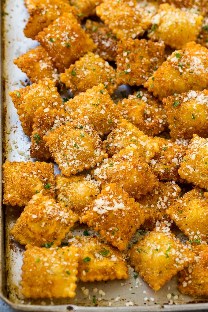 Una sartén llena de albóndigas fritas con queso parmesano.