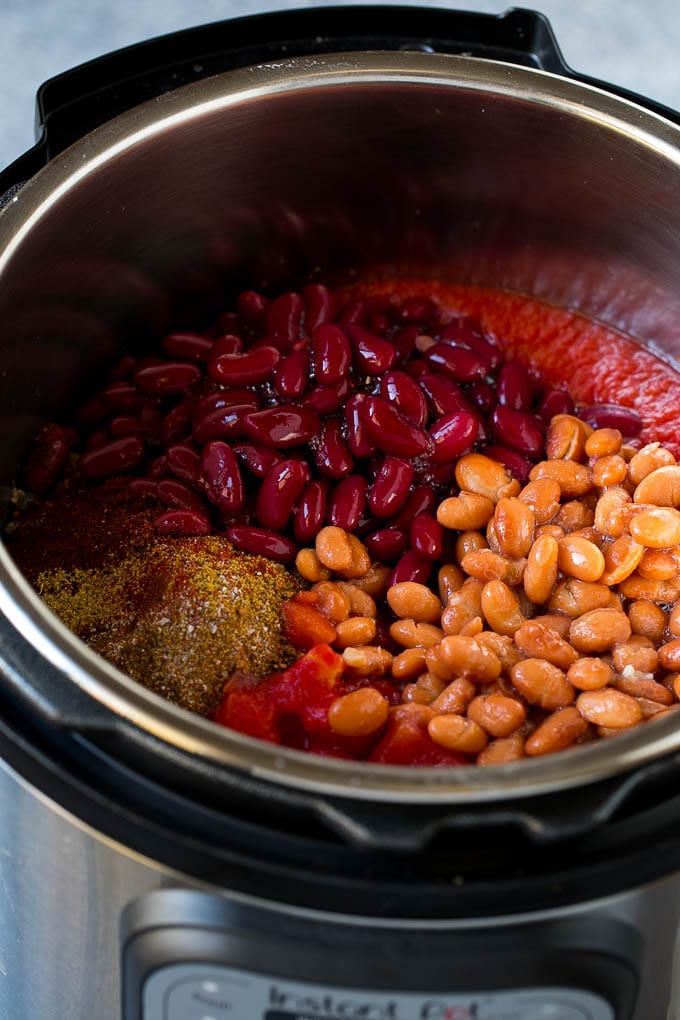 Frijoles Borlotti, frijoles, especias y tomates en una olla instantánea.