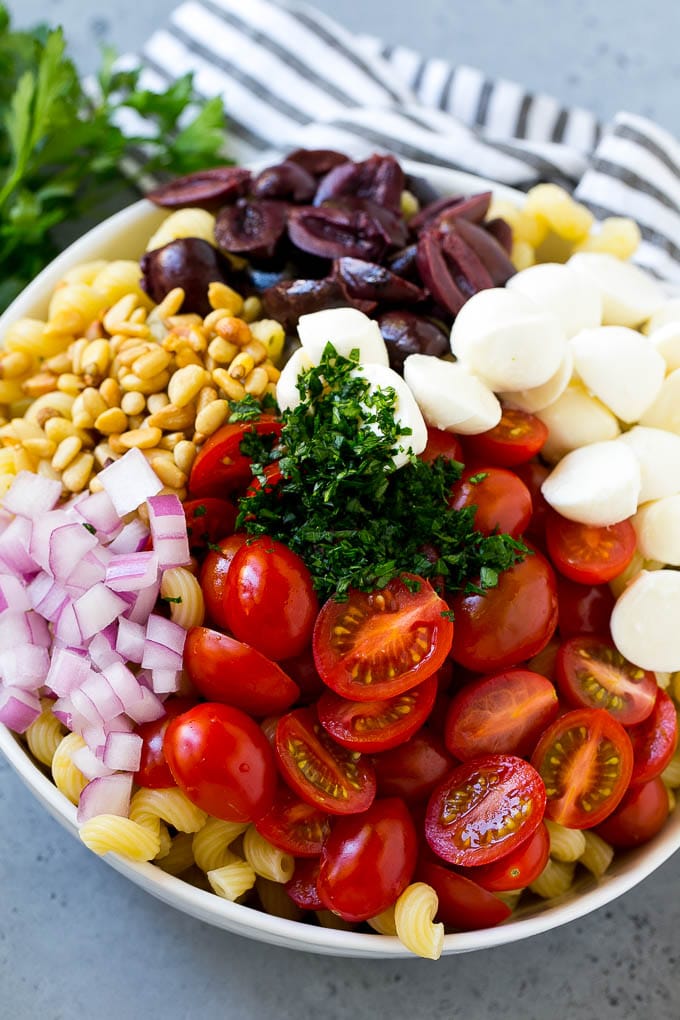 Pasta con tomates cherry, bolitas de mozzarella, aceitunas kalamata, perejil y cebolla morada.