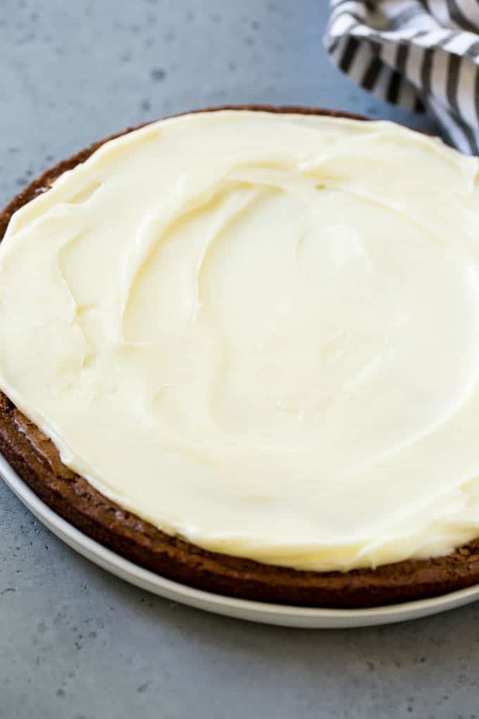 Una galleta redonda grande con glaseado de queso crema.