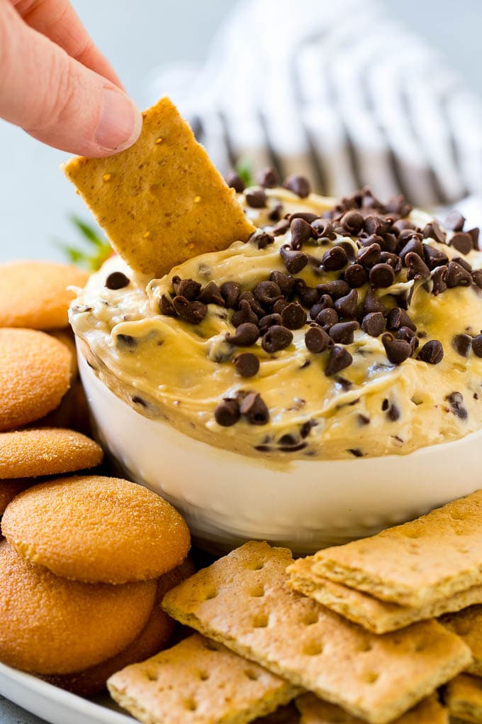Una galleta Graham sumergida en un tazón de masa para galletas.