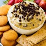 Salsa de masa para galletas con chispas de chocolate, cubierta con mini chispas de chocolate y servida con galletas Graham y obleas de vainilla.