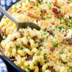 Una sartén de macarrones con queso jalapeño cubierto con pan rallado crujiente, cilantro y tocino.