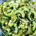 Ensalada de pepino y feta con aguacate, eneldo y cebolla roja, todo mezclado en una vinagreta griega.