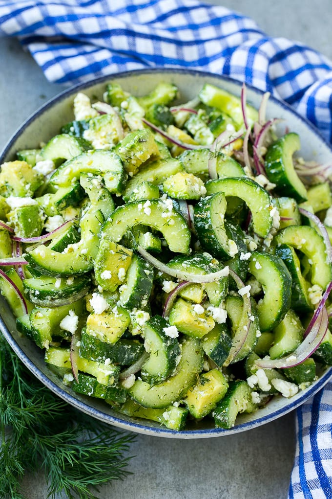 Un tazón de ensalada de aguacate, pepino y queso feta.