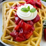 Los gofres de fresa son gofres caseros cubiertos con salsa de fresa fresca y crema batida.