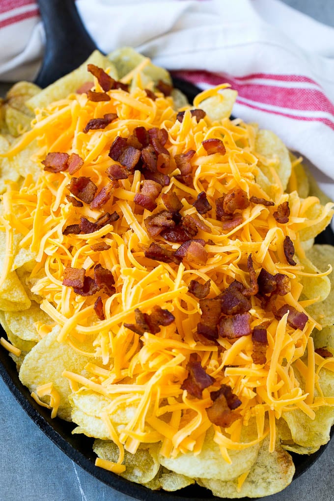 Papas fritas cubiertas con queso rallado y tocino.