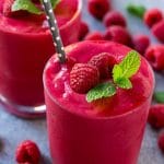 Un batido de frambuesa aderezado con menta y frutos rojos, con una pajita.
