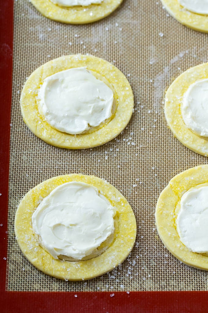Aros de hojaldre cubiertos con un relleno de queso crema dulce.