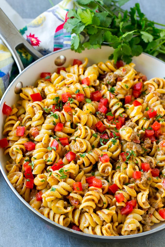 Una sartén de pasta para tacos cubierta con tomates frescos cortados en cubitos y cilantro.