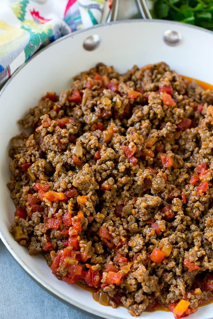 Una sartén de carne molida cocida y tomates.