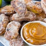 Un plato de patatas fritas recubiertas de azúcar y canela, servido con salsa de caramelo.
