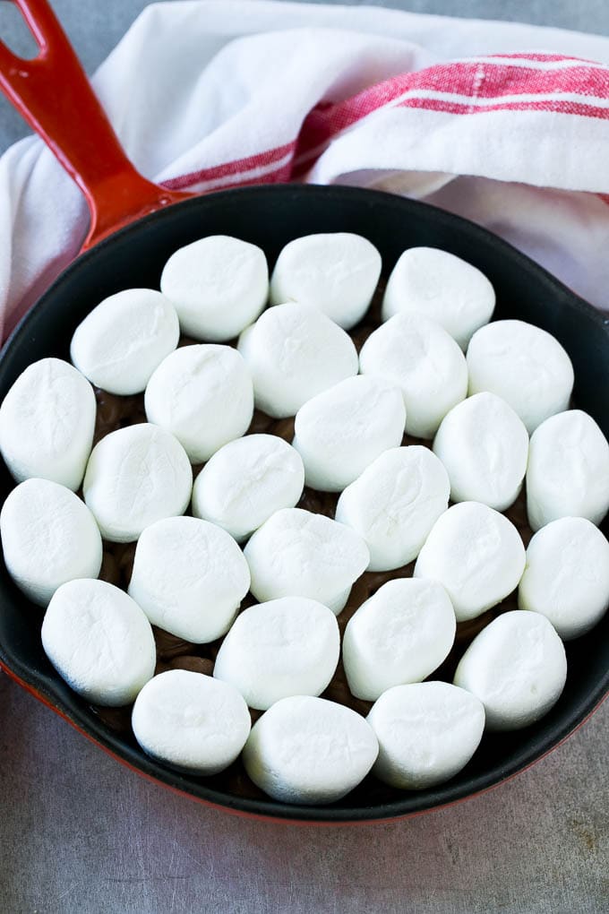 Una cazuela de chispas de chocolate cubierta con malvaviscos enteros.