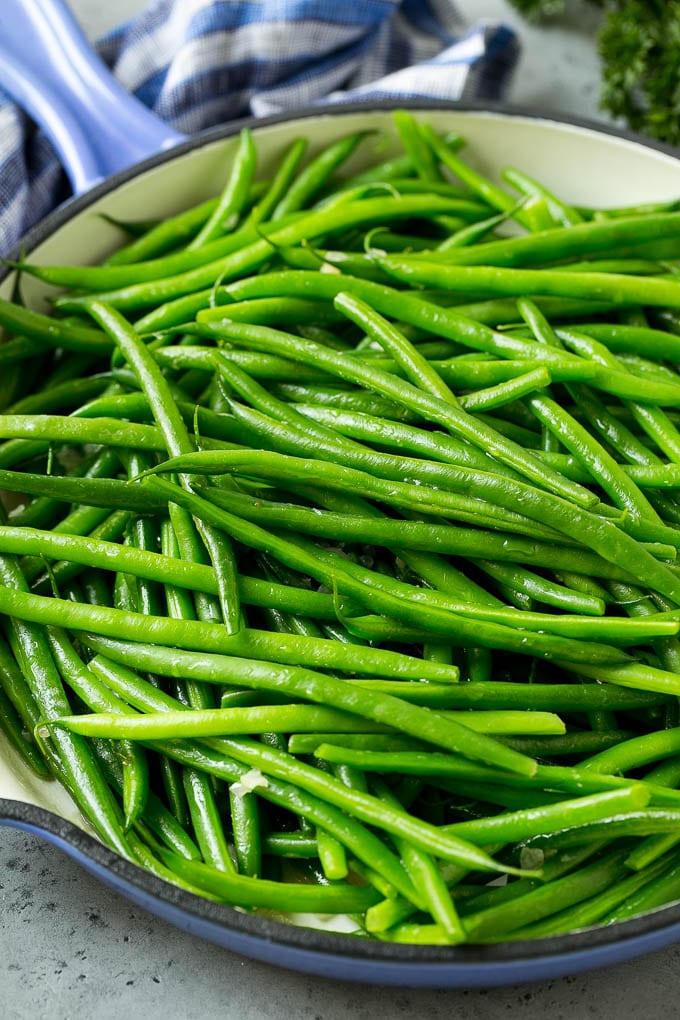 Judías verdes cocidas en mantequilla de chalota en una sartén.