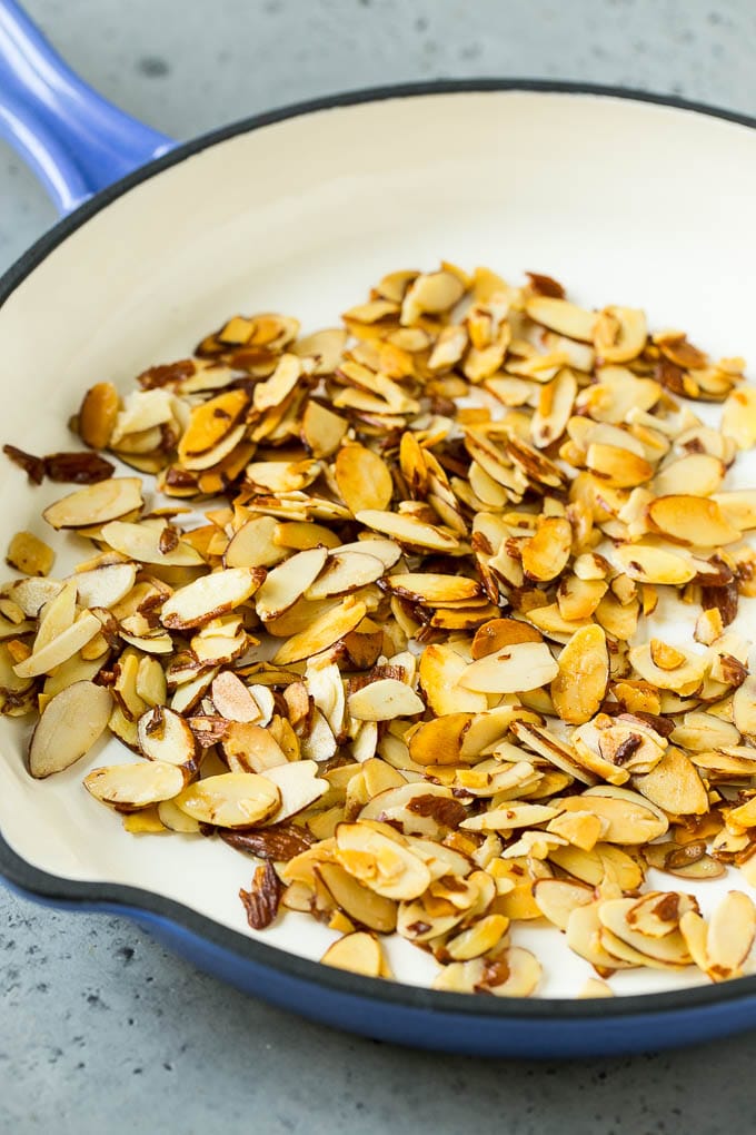 Unte con mantequilla las almendras tostadas en una sartén.