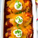 Un plato de pollo al horno con salsa cubierto con queso y crema agria.