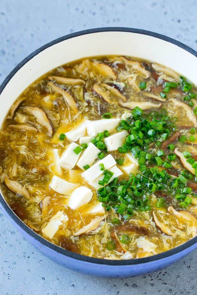 Sopa agridulce con tofu cortado en cubitos y cebollas verdes.