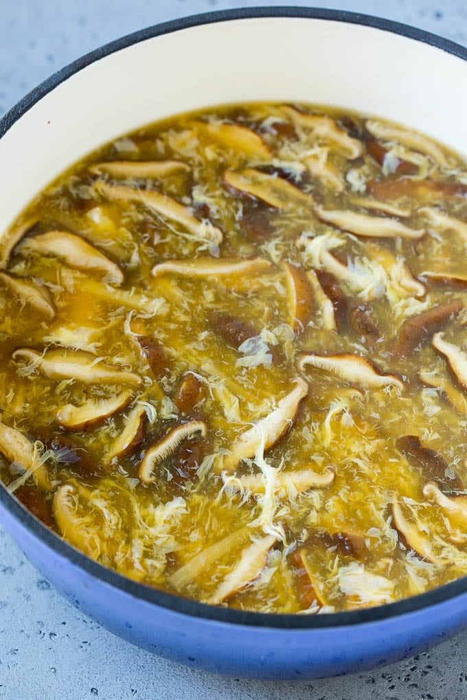Hongos, hebras de huevo y brotes de bambú en un caldo de sopa caliente, agridulce.