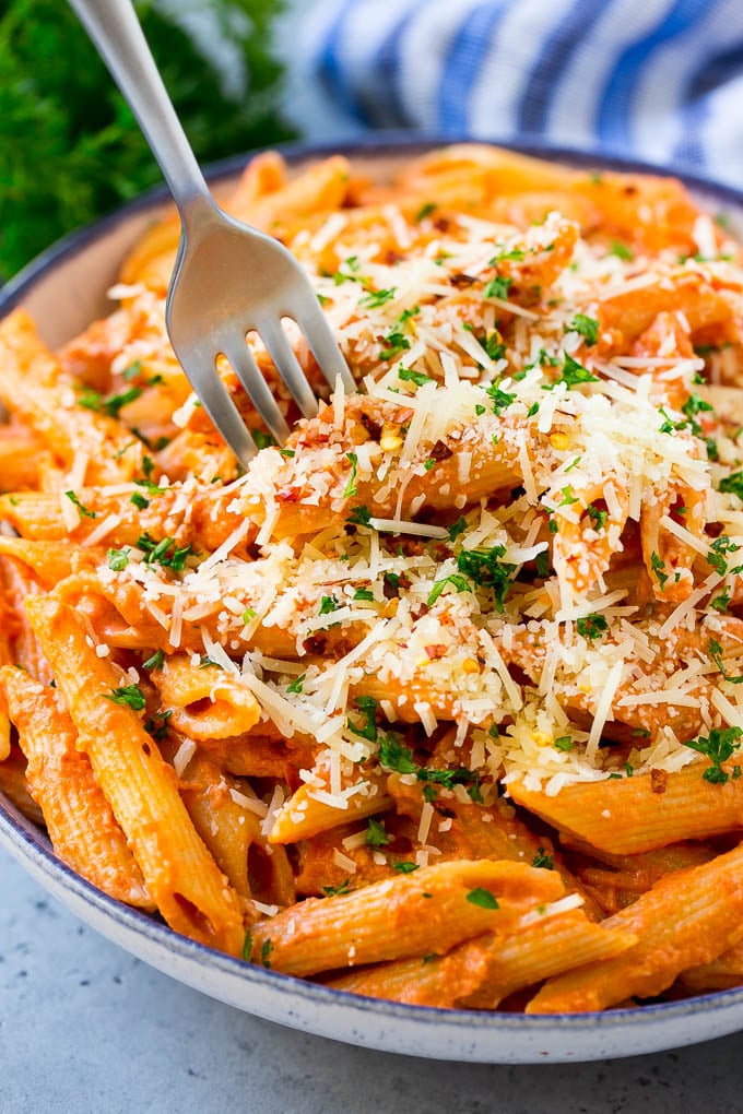 Un cuenco de vodka penne iba acompañado de un tenedor.