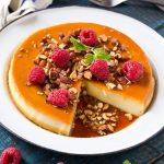 Este rico y cremoso flan está aromatizado con vainilla y almendras y se completa con almendras tostadas picadas y frambuesas.  #ANUNCIO