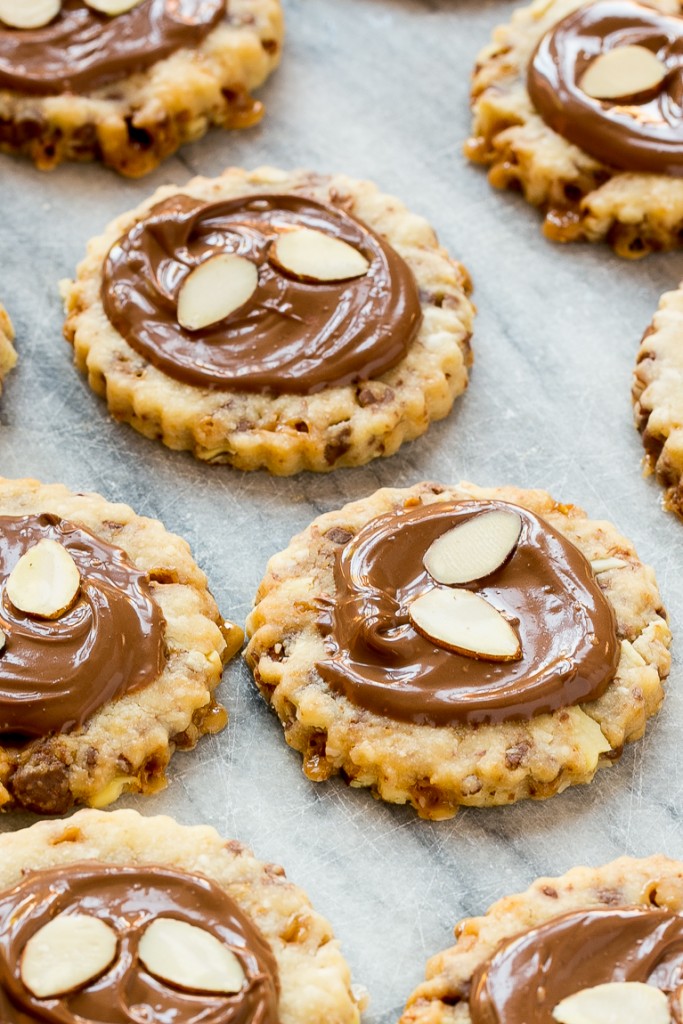 Estas galletas de almendras roncas están cargadas con caramelo y almendras y adornadas con chocolate con leche cremoso. #BakeMagicMoments # Anuncio de orientación