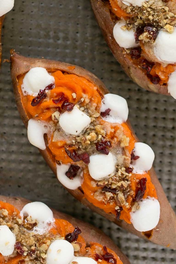 Estas batatas de doble carga se rellenan con streusel de nueces con azúcar morena, malvaviscos y arándanos secos.  ¡Puede prepararlos con anticipación y ponerlos en el horno justo antes de la comida navideña!