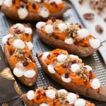 Estas batatas de doble carga se rellenan con streusel de nueces con azúcar morena, malvaviscos y arándanos secos.  ¡Puede prepararlos con anticipación y ponerlos en el horno justo antes de la comida navideña!